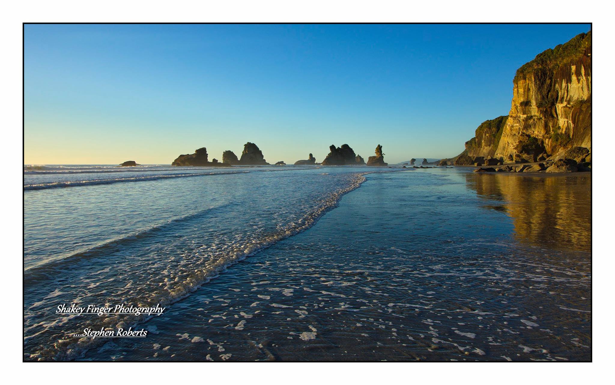 motukiekie beach and rocks as the sun goes down